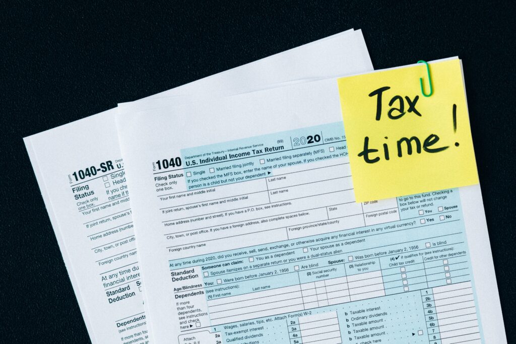 Image of 1040 tax forms with sticky note that says tax time.