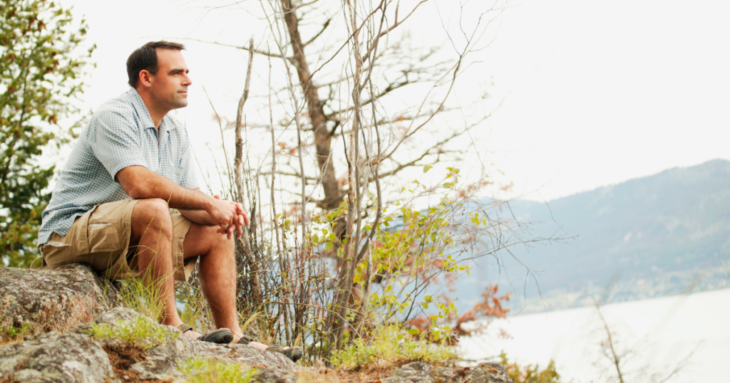 A man thoughtfully waiting for his financial advisor to reach out to him.