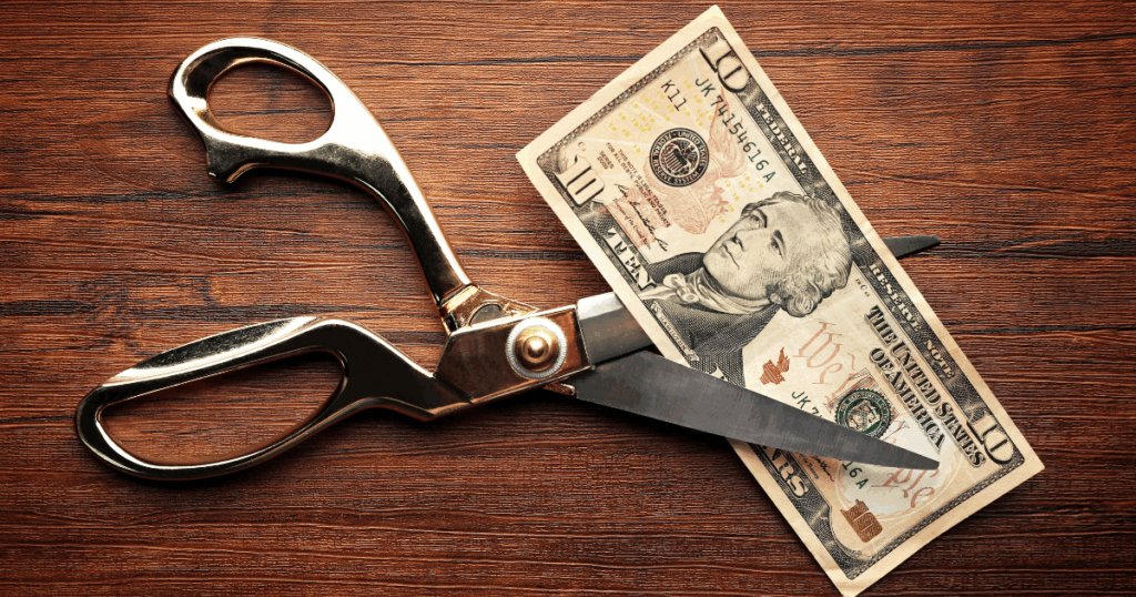 Image illustrates a $10 bill being cut in half representing the spending cuts and policy changes by the OBBBA